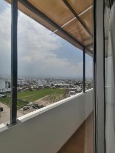 ein Blick auf eine Stadt aus einem Fenster in einem Gebäude in der Unterkunft Las cumbres del mirador in La Libertad
