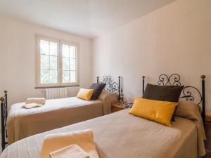 Un dormitorio con dos camas y una ventana. en Villa il Carrubo, en Cala Gonone