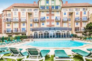 una piscina frente a un gran edificio en Résidence Port Guillaume - maeva Home - Studio 2 personnes Sélection MAE-3802, en Dives-sur-Mer