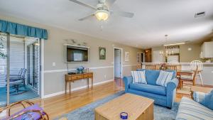 a living room with a blue couch and a table at 57C Fifty-Seven Sea at True Blue condo by Peace Vacations in Pawleys Island