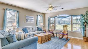 a living room with a couch and chairs and windows at 57C Fifty-Seven Sea at True Blue condo by Peace Vacations in Pawleys Island