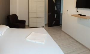 奥拉迪亚Carla's place Ap1的卧室里有一张白色的床，床上放着一条毛巾