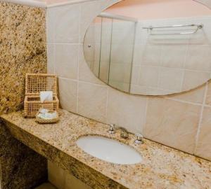 a bathroom with a sink and a mirror at Baía Branca Beach Resort in Tamandaré