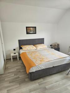 - une chambre avec un grand lit et une tête de lit grise dans l'établissement Apartments Zalar Bled, à Bled