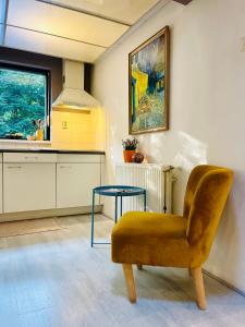 a kitchen with a chair and a table in it at Magical Cottage in the woods in Baarn +29 photos