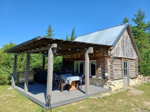 a wooden cabin with a table on a deck at Intsu suvemaja in Liiva