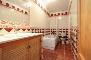 ein Badezimmer mit Waschbecken, Toilette und Badewanne in der Unterkunft Casa Macau T4 com piscina in Pousadas + 18 Fotos