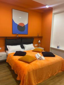 a bedroom with a large bed with orange walls at Vere Side Hotel in Tbilisi City