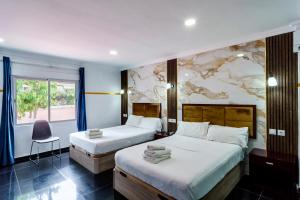 ein Hotelzimmer mit zwei Betten und einem Fenster in der Unterkunft Villa Costa Marbella in Marbella + 127 Fotos