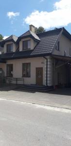 a large white house with a black roof at Zajazd Stok in Górecko Stare