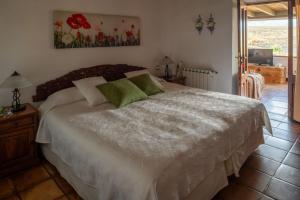 a bedroom with a large white bed with green pillows at Casa Amanecer in Haría