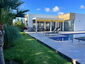 a villa with a swimming pool and a house at Villa prestige in Essaouira