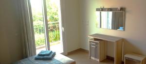 a bedroom with a bed and a mirror and a window at Villa Krina Rosa Aigio in Elíki +109 photos