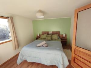 a bedroom with a large bed and a television at Casa Giovanna in Puerto Natales