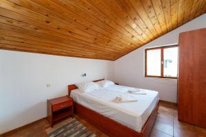 Un dormitorio con una cama con techo de madera. en Dodo Sea View Apartments, en Novalja