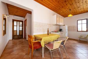 Una cocina y un comedor con mesa y sillas. en Dodo Sea View Apartments, en Novalja