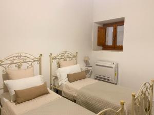 a bedroom with two beds and a air conditioner at CaTó - Le vacanze come a casa tua in Carloforte