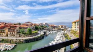 a view from a window of a river with boats at Apartamento El Mirador del Puerto in Llanes