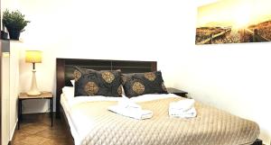 a bedroom with a bed with two towels on it at VIP Apartamenty Sienkiewicza in Zakopane
