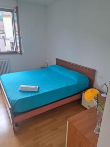 a bedroom with a bed with a blue sheet at Appartamento turistico Acquamarina in La Spezia