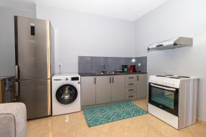 a kitchen with a refrigerator and a washing machine at Lixourious Apartment in Lixouri