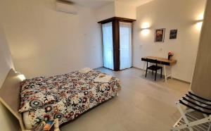 a bedroom with a bed and a desk and a table at Lettera 22 Apartment in Brindisi