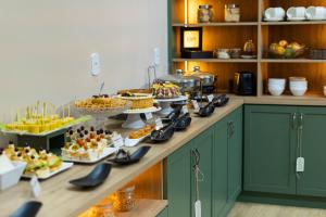 ヴィラ・ヴェーリャにあるHotel Prainhaのカウンターにさまざまな種類の食べ物が並んだビュッフェ