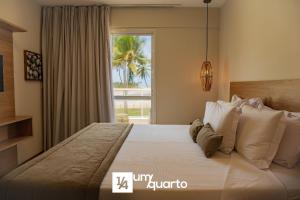 a bedroom with a large bed with a window at Ponta de Inhambupe Residences in Baixio