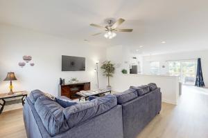 a living room with a blue couch and a ceiling fan at Pebble Point Cove in Salisbury