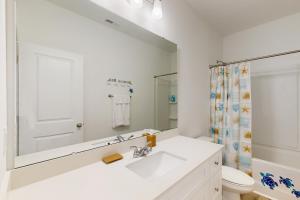 a white bathroom with a sink and a mirror at Pebble Point Cove in Salisbury
