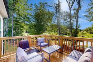 a deck with two chairs and a table and a bench at Pebble Point Cove in Salisbury