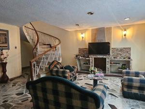 a living room with couches and a staircase with a television at Colisseum Roma - Vive Claro -El cubo movistar campin in Bogotá