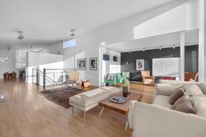 a living room with two white couches and a table at Funkisvilla med panoramautsikt in Tromsø