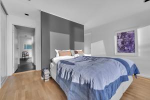 a bedroom with a large bed with a blue blanket at Funkisvilla med panoramautsikt in Tromsø
