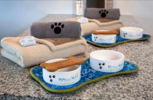 a counter top with bowls and cups and paws towels at Inn By the Sea in Cape Elizabeth