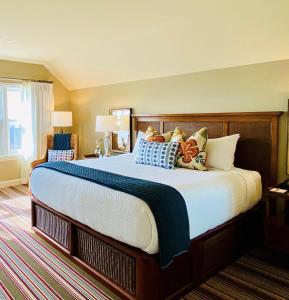 a bedroom with a large bed with colorful pillows at Inn By the Sea in Cape Elizabeth