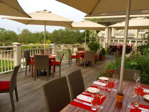a restaurant with tables and chairs and umbrellas on a deck at Inn By the Sea in Cape Elizabeth