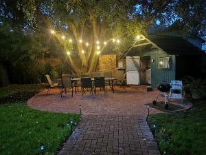 a patio with a table and chairs under a tree at Huys ten Bosch in Potchefstroom