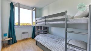 een slaapkamer met twee stapelbedden en een raam bij La Goelette 30 in Saint-Hilaire-de-Riez