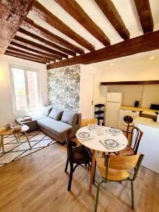 a living room with a table and a couch at Beau 2 pièces charme et confort in Dieppe
