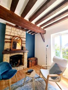 a living room with a stone fireplace and blue walls at Beau 2 pièces charme et confort in Dieppe
