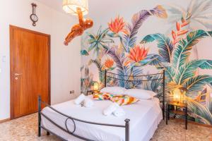 a bedroom with a bed with a tropical wallpaper at Esclusiva Residenza con 2 Suite in Centro Città, Mare a 750m, Parcheggio a 300m in Pescara