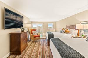 a hotel room with two beds and a balcony at Inn By the Sea in Cape Elizabeth