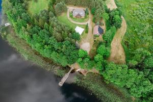 an aerial view of a house on a farm next to the water at Pakaso sodyba in Kirdeikiai