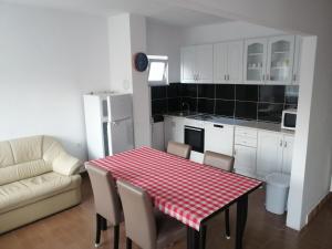 eine Küche mit einem roten und weißen karierten Tisch und Stühlen in der Unterkunft Apartments Kabalin 2 in Novi Vinodolski