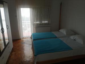 ein Schlafzimmer mit einem großen Bett mit blauer Bettwäsche in der Unterkunft Apartments Kabalin 2 in Novi Vinodolski