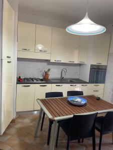 a kitchen with a wooden table with chairs and a sink at Casa Vacanza Violet 2 in Torre Dei Corsari
