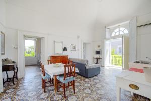 Una sala de estar con una mesa y un piano. en Casa Elsa, en Procida