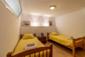 2 Betten in einem Zimmer mit gelber Bettwäsche in der Unterkunft RentitSpain Finca Ecológica Almahen en Salobreña in Salobreña + 19 Fotos