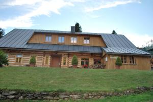 uma grande casa de madeira com um telhado de metal em Guest House U Marie em Pec pod Sněžkou